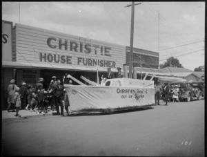 Christie House Furnisher's building, with boat float and crew for parade in front of store, locals looking on, Hastings, Hawke's Bay District