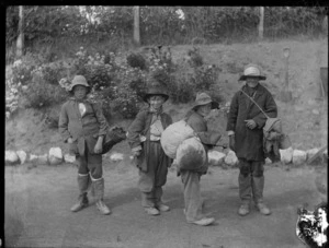 Children in fancy dress, boys dressed as tramps with swags and hats, one hat has a note pinned to it saying 'it's a long way to Wembley'