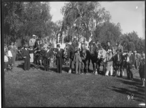 Country horse race meeting, a group of unidentified men standing alongside jockeys on their horses, location unidentified