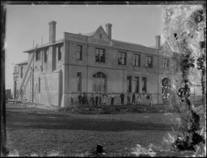 A group of unidentified men in front of the Latter-Day Saints Maori Agricultural College doing maintenance work on the building, Hastings