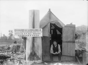 Small hut in the Taranaki district with a sign advertising board and lodgings