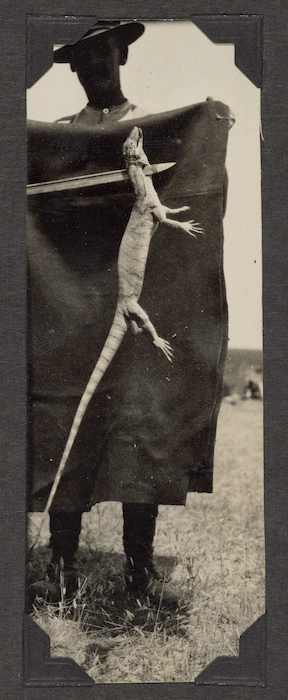 Soldier holding dead lizard, Palestine