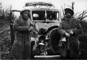 Soldiers of 2nd NZEF 27 Machine Gun Battalion alongside their vehicle which was damaged by a German air attack