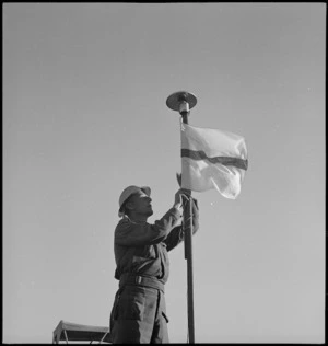 C L Devereaux hoisting the Signals flag in the Western Desert, World War II - Photograph taken by H Paton