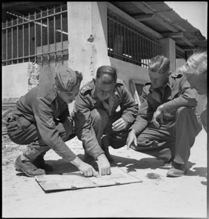 Comparing notes on the map as 5th and 8th Armies meet in Sousse, Tunisia, World War II - Photograph taken by H Paton