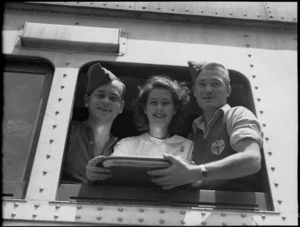 Two repatriated soldiers and a Red Cross worker look out train window at Alexandria on the way to Cairo, World War II - Photograph taken by H Paton