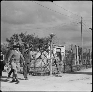 Sergeant Major Young leads party of Yugoslavs to help unload rations at refugee camp near Bari, Italy, - Photograph taken by W A Brodie
