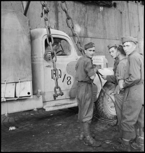 Italian soldiers assist with unloading NZ Division vehicle onto wharf at Bari, Italy, World War II - Photograph taken by G F Kaye