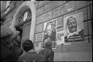 Italians surveying posters on a building in an area occupied by NZ Division, Italy, World War II - Photograph taken by G Kaye