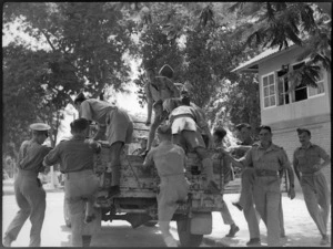 New Zealand soldiers going on leave clamber on an army vehicle at Maadi, Egypt, World War II - Photograph taken by G Kaye