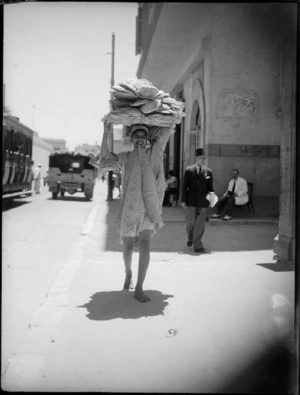 Man carrying bread on his head in Cairo - Photograph taken by George Kaye