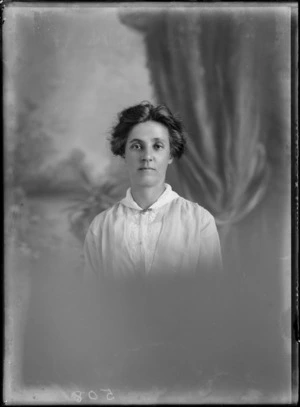 Studio upper torso portrait of an unidentified woman, dressed in a [nurses uniform?], with a brooch attached to the neckline, possibly Christchurch district