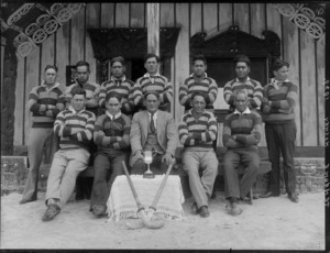 Te Hauke men's hockey team, in front of a Maori meeting house, Hawkes Bay district