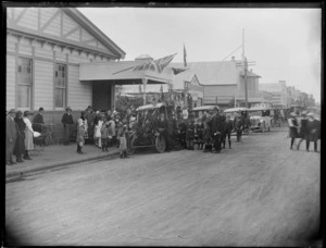 Children and some adults gathered around a decorated truck on an unidentified street in Hastings, AA George's Bulletin Printing Works is in the background