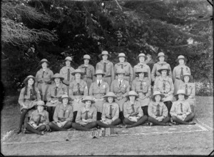 Outdoor on grass with trees beyond, a group portrait of twenty three unidentified members of the Peace Scouts in full uniforms, probably Christchurch region