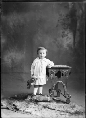 Studio portrait of unidentified child holding teddy bear, probably Christchurch