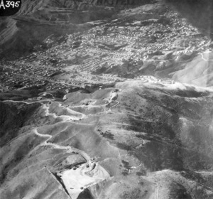 Aerial view over Karori, Wellington, showing the construction of coastal defence works at Wright's Hill during World War II