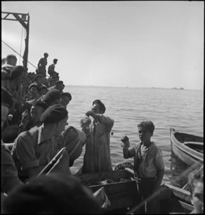 Members of 2 NZ Division bargaining with bumboats on arrival in an Italian port, World War II
