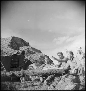 New Zealanders alongside camouflaged vehicle in forward area of the Italian battlefront, World War II - Photograph taken by George Kaye