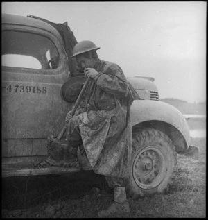 I F Jones cleaning mud off his boots on the way to the Italian front lines, World War II - Photograph taken by George Kaye