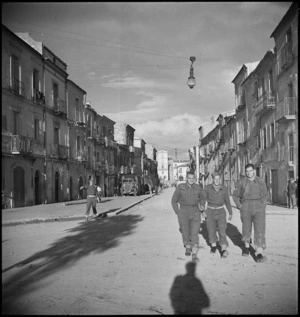 New Zealand soldiers walking down a street in the Italian village of Gissa, World War II - Photograph taken by George Kaye