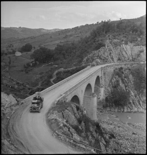 Truck crossing bridge under German observation and fire in the Sangro River area, Italy - Photograph taken by George Kaye