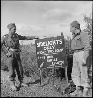New Zealand soldiers read first warning sign erected by NZ Division in Italy, World War II - Photograph taken by George Kaye