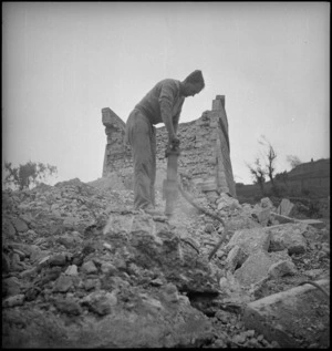 NZ engineer using pneumatic drill to clear ruins of demolished bridge in Sangro River area, Italy, World War II - Photograph taken by George Kaye