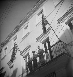 NZ soldier stands with American and British soldiers on a balcony of a building in Atessa, Italy, World War II - Photograph taken by George Kaye