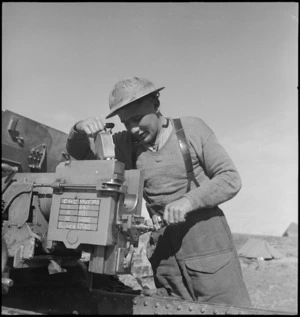 D McKenna oils the breech block of 25 pounder on the Sangro River front, Italy, World War II - Photograph taken by George Kaye