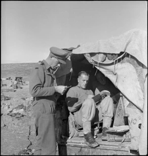 Lt M J Black, gun position officer on the Sangro, dictates message to wireless operator, G Hansen, World War II - Photograph taken by George Kaye