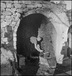 R W Markham in his improvised cookhouse in local farmhouse in the Sangro area, Italy, World War II - Photograph taken by George Kaye