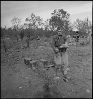 R J Burke taking up signal wire when artillery moves position in Sangro battle, World War II