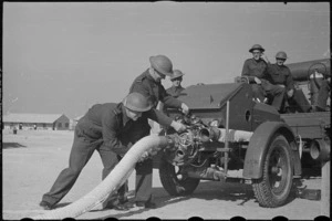 Members of NZ Maadi Camp Fire Unit coupling up suction hose during training, Egypt, World War II - Photograph taken by George Bull
