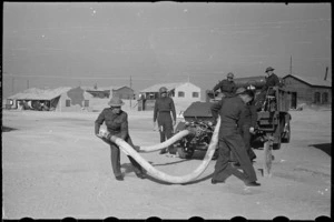 Members of NZ Maadi Camp Fire Unit coupling up suction hose during training, Egypt, World War II - Photograph taken by George Bull