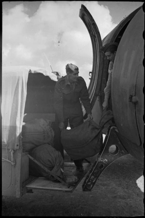 Bags of the NZEF Times are loaded into an RAF aeroplane for transport to Italy, World War II - Photograph taken by George Bull