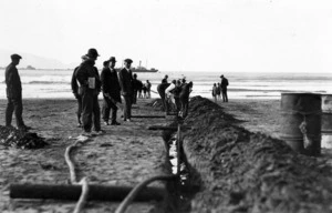 Crown Studios :Photograph of men laying telephone cable at Lyall Bay beach, 1926