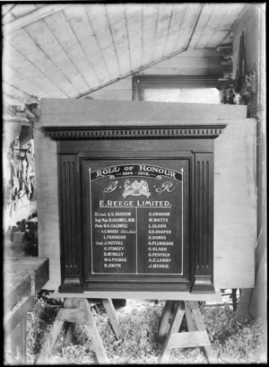 Inside a woodwork shop with tools on the wall behind, view of a wooden wall plaque under construction for a 'Roll of Honour 1914-1918' for local soldiers who served during World War I, commissioned by E Reece Limited, Christchurch