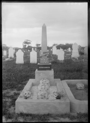 Outdoors grave plot with flowers and headstone of 'Henry Wood, beloved husband of Clara' passed away on September 13th 1922, with other headstones beyond
