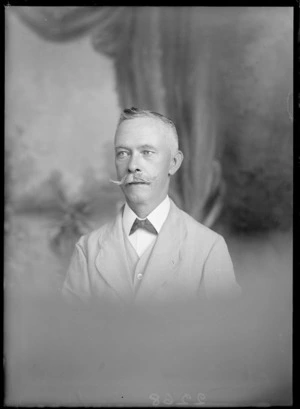Studio upper torso portrait of unidentified man with a large handle bar moustache and a black bow tie in a light coloured cloth suit, Christchurch