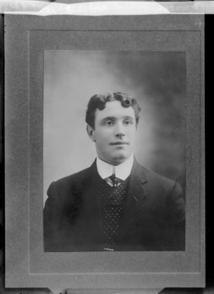 Studio upper torso portrait of an unidentified young man with matching waistcoat and tie with tie pin, location unknown.