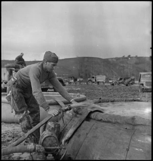 NZ engineer filling canvas tank to store water at water point on the Sangro River in Italy, World War II - Photograph taken by George Kaye
