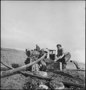 A J Gower adjusts hose leading to canvas water tank on the bank of the Sangro River, Italy, World War II - Photograph taken by George Kaye