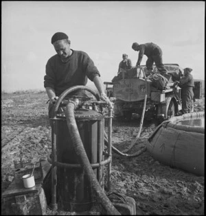 A V Reid with apparatus used to filter water drawn from the Sangro River in Italy, World War II - Photograph taken by George Kaye