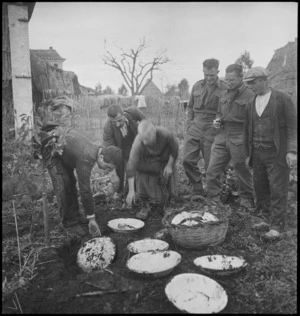 NZ soldiers watch returning Italian family unearthing crockery, during World War II - Photograph taken by George Kaye