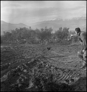 W Hanley points out direction taken by unexploded bomb that rolled away in Italy, World War II - Photograph taken by George Kaye