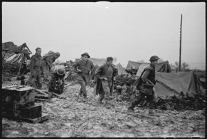 New Zealand Artillery personnel carrying ammunition through mud and slush on the Italian Front, World War II - Photograph taken by George Kaye