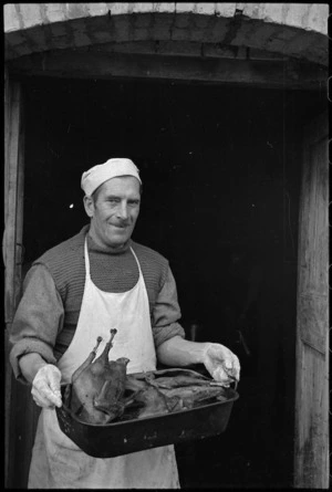 W Sims with roast Christmas turkey in cookhouse of PRS Field Section, Italy, World War II - Photograph taken by George Kaye