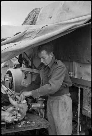 G A O'Loughlin prepares a turkey for Christmas dinner in Italy, World War II - Photograph taken by George Kaye