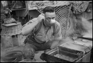 W T Keighley tastes part of the Christmas dinner for a section of NZ Division in Italy, World War II - Photograph taken by George Kaye